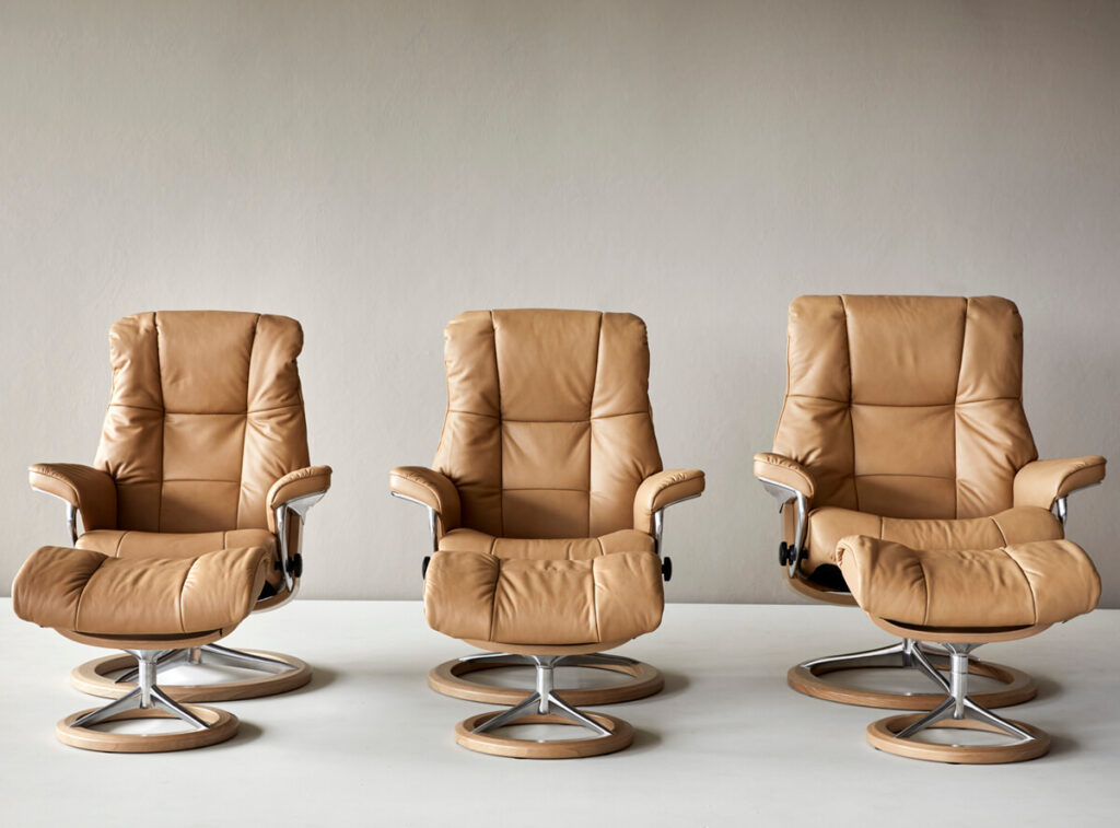 Drei Stressless Sessel in den verschiedenen Größen nebeneinander. Mit Signature Untergestell und Lederbezug