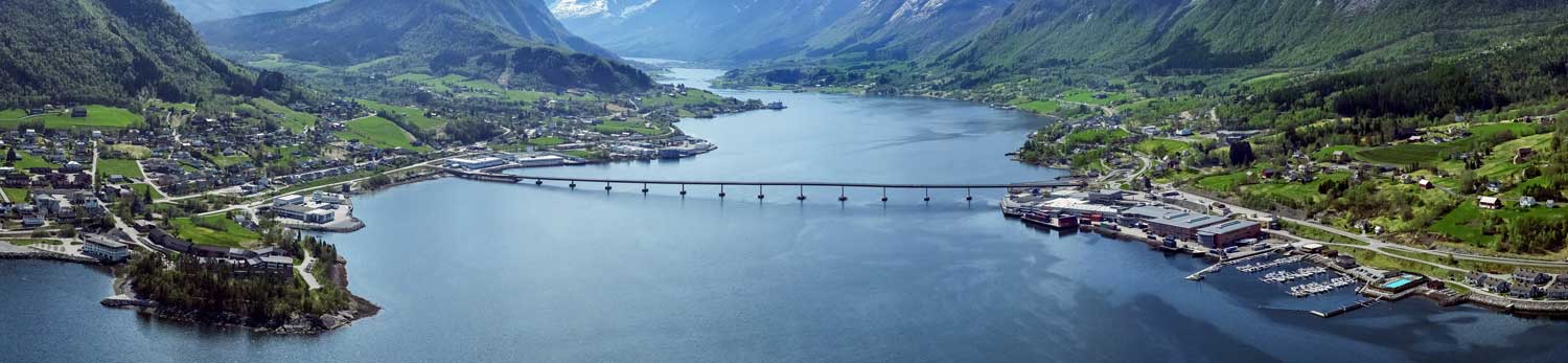 Stressless Fabrik am Fjord in Norwegen, bergige Landschaft mit Fjord und Brücke