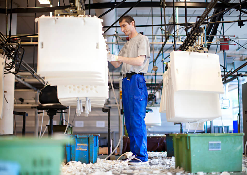 Bild aus der Stressless Fabrik in Norwegen. Ein Arbeiter fertigt die Sitzkissen der Stressless Sessel an